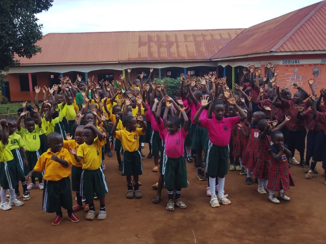 Pupils raising their hands together in the school compound