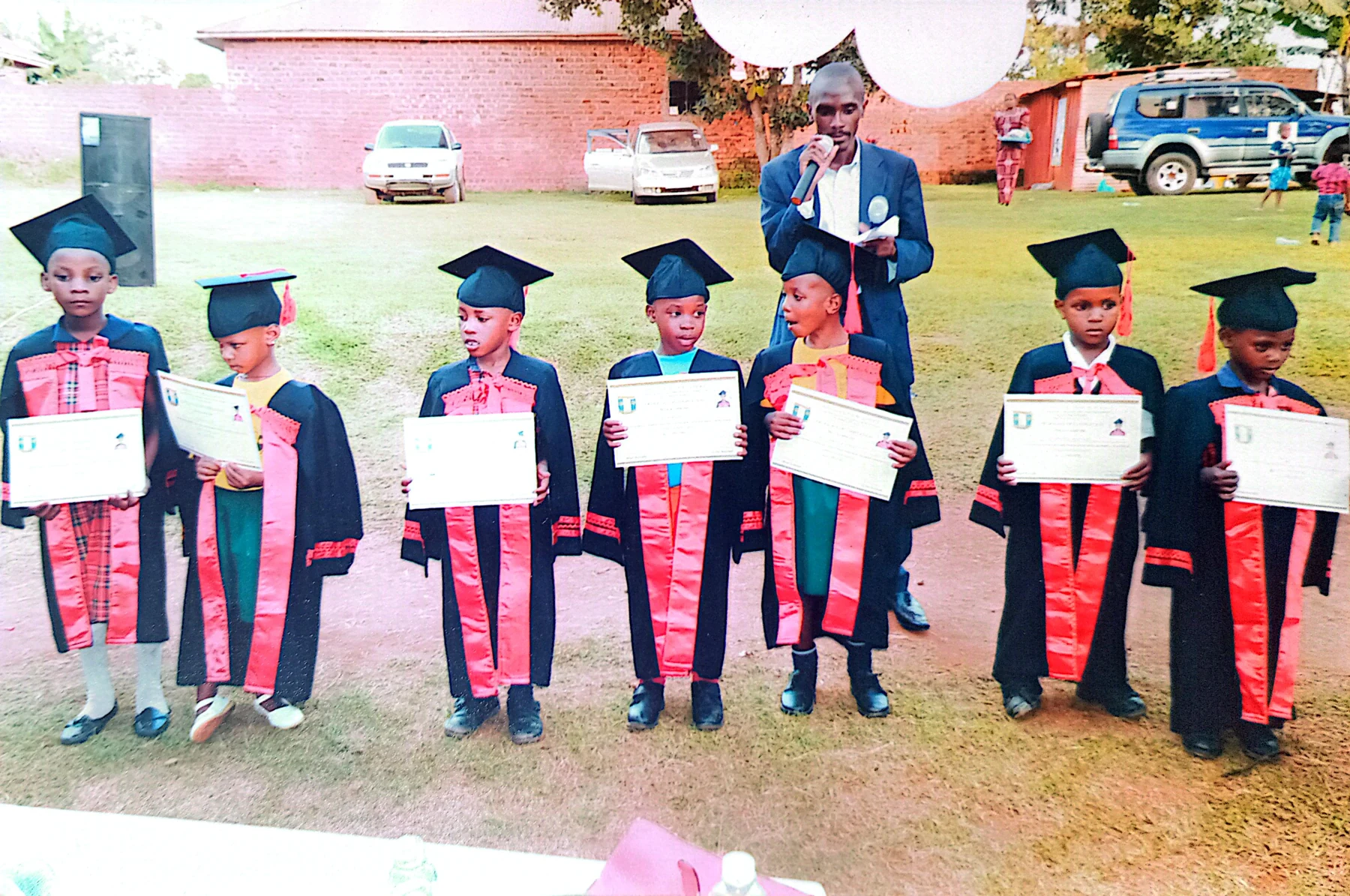 Children standing with their certificates alongside staff